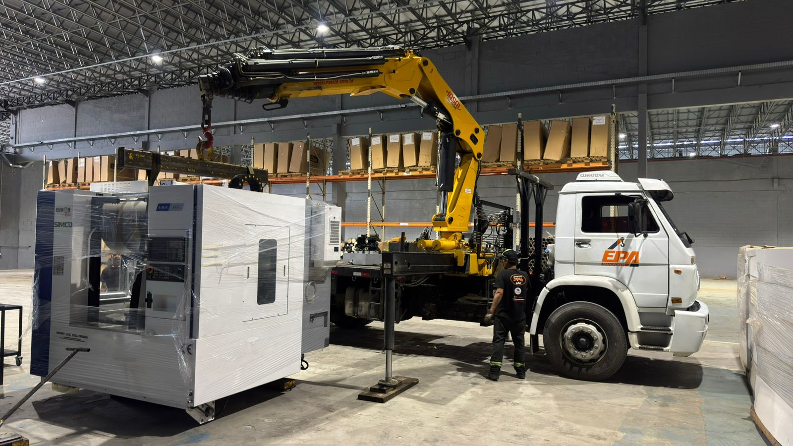 Guindauto movimentando equipamento pesado em ambiente industrial